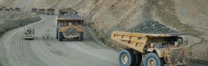 dump trucks carrying rock payloads on dirt road