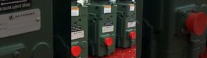 Close-up of industrial marine drive shaft rotation hydraulic control units with red protective caps