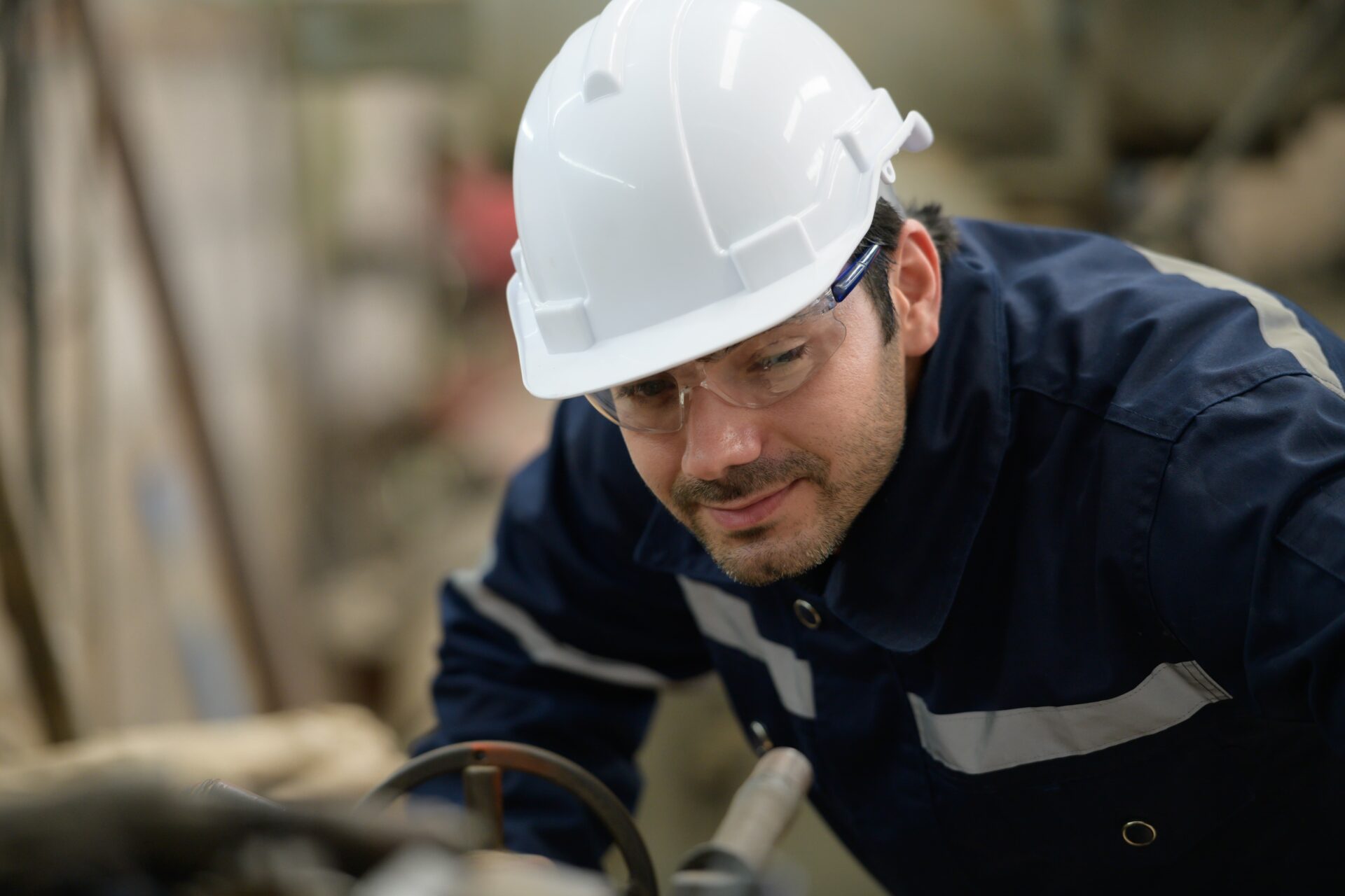Worker on-site with a hard hat recording performance metrics.
